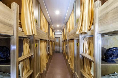 a hallway in a train with wooden walls and wooden shelves at ABZA DELUXE DORMITORY in Mumbai