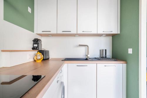 a kitchen with white cabinets and a sink at Jacques Cartier - ideal lake of Nantua in Montréal La Cluse
