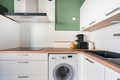 a kitchen with a washing machine and a sink at Jacques Cartier - ideal lake of Nantua in Montréal La Cluse