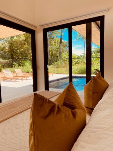 - une chambre avec un lit et une vue sur la piscine dans l'établissement Casa Emateena, à Uvita