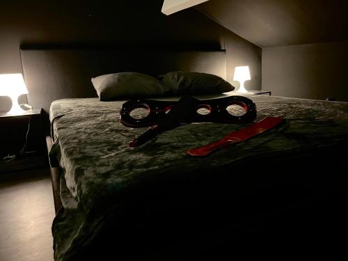 Una cama con un par de gafas encima. en Amour d'une Nuit, LoveRoom en Sarcelles