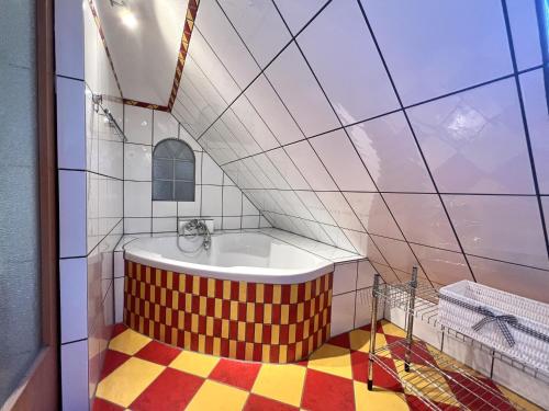een badkamer met een bad met een geometrische vloer bij Dat Dörphuus in Krummhörn