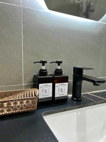 two bottles of soap and a sink in a bathroom at December HomeStay Studio in Ho Chi Minh City