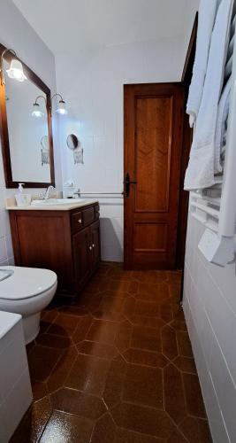 a bathroom with a toilet and a sink and a door at La Elegida in Denia