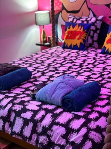 - un lit violet avec des oreillers au-dessus dans l'établissement GAME ZONE Maison Unique hyper centre ville, proche toutes commodités, à Magenta
