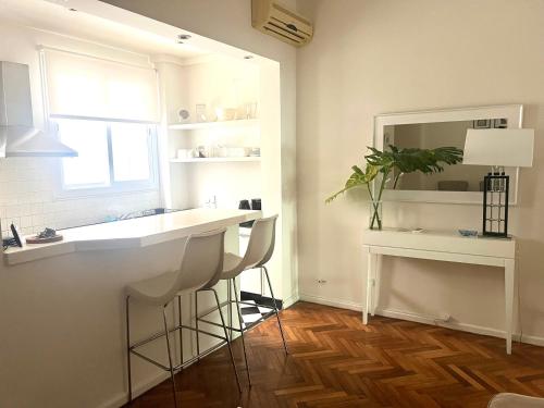 een keuken met een aanrecht, een wastafel en een spiegel bij Apartamento en Recoleta in Buenos Aires