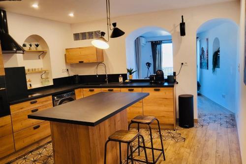 a kitchen with a island and two bar stools at Merveille de loft vue mer Citadelle de Bonifacio in Bonifacio