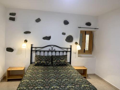 Schlafzimmer mit einem Bett mit grüner Tagesdecke in der Unterkunft Casa (bajo), Tasarte. in Playa de Tasarte