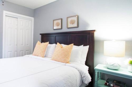 um quarto com uma grande cama branca com almofadas em Apartment Located in Historic District Mins to Downtown, Beaches & Convention Center em Long Beach