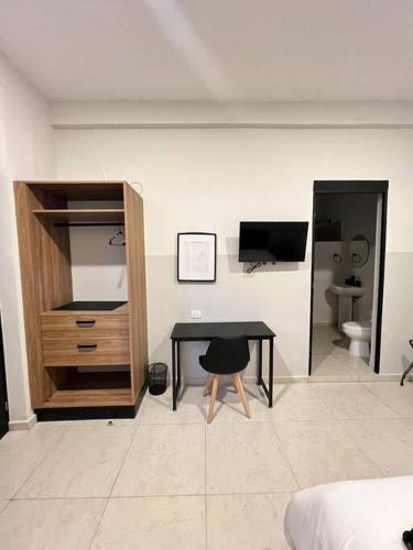 Habitación con escritorio, TV y dormitorio. en Lofts, en Villahermosa