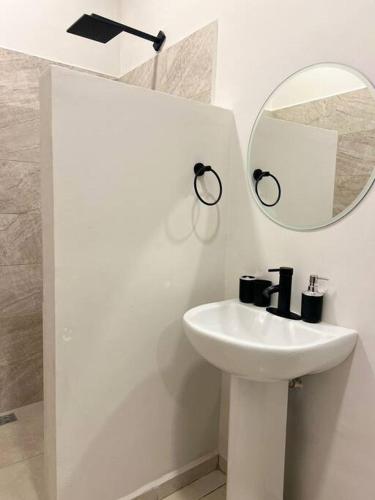 Baño blanco con lavabo y espejo en Lofts, en Villahermosa
