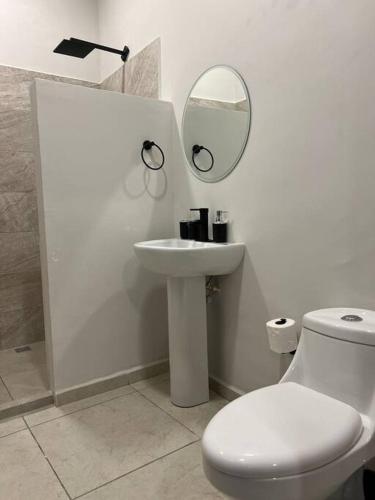 Baño blanco con lavabo y espejo en Lofts, en Villahermosa