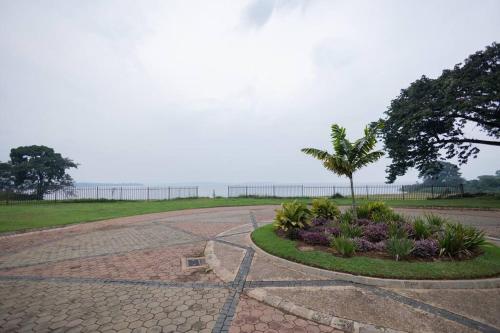 a walkway with a palm tree and flowers in a park at Apartment in Entebbe 2 in Wakiso