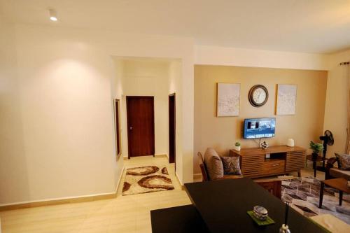 a living room with a couch and a clock on the wall at Apartment in Entebbe 2 in Wakiso