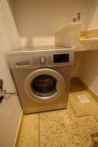 a washing machine in the corner of a bathroom at Apartment in Entebbe 2 in Wakiso