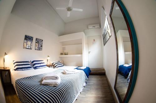 a bedroom with two beds and a large mirror at BA Stop Hotel House in Buenos Aires