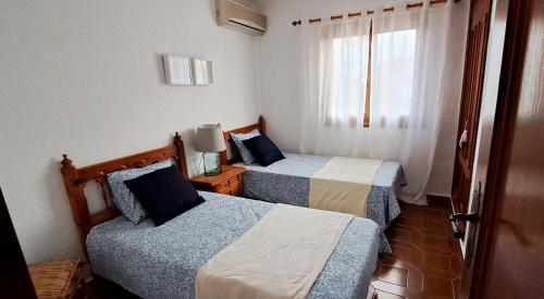 ein Hotelzimmer mit zwei Betten und einem Fenster in der Unterkunft La Elegida in Denia