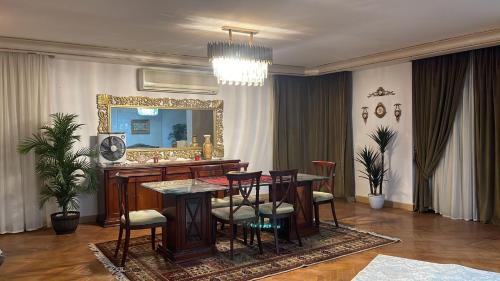 een eetkamer met een tafel en een spiegel bij Luxury Apartment Nasr City in Caïro