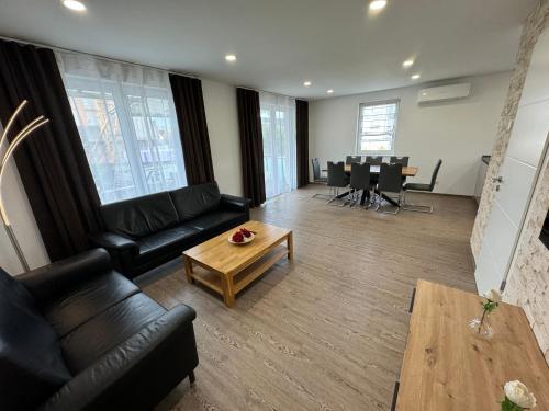 a living room with black leather furniture and a table at Kern Apartments in Rust