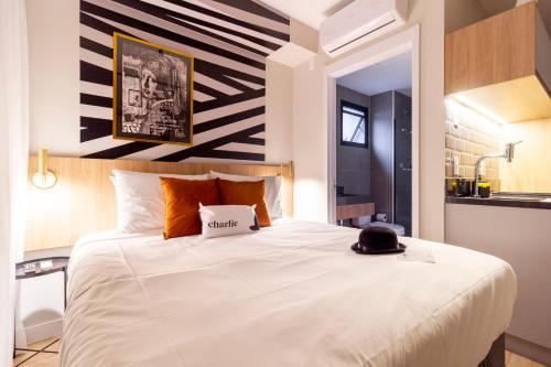 Charlie Uwin Brooklin في ساو باولو: غرفة نوم بسرير ابيض كبير وعليه قبعة