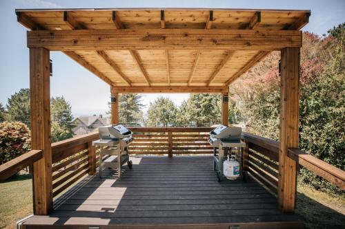 a wooden pergola with two stools on a wooden deck at View Crest Lodge in Trinidad