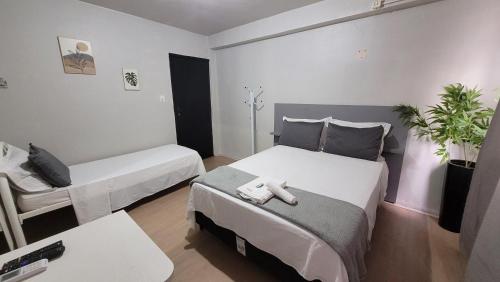 a small room with two beds and a table at Hotel e Restaurante do Baixinho in Planalto