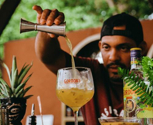 a man pouring a drink into a wine glass at Viajero Tayrona Hostel & Ecohabs in Buritaca
