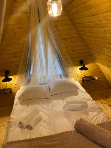 Łóżko w drewnianym pokoju z oknem w obiekcie Sunny Side Cottage w mieście Stepancminda