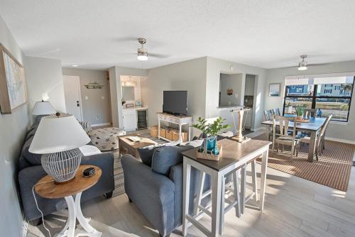 a living room with a blue couch and a table at Sea Oats B105 by ALBVR - Pet Friendly - Balcony - Easy Beach Access! in Gulf Shores