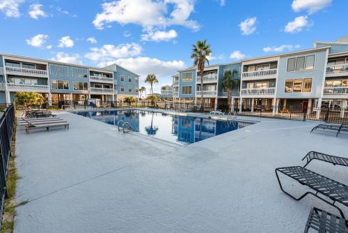 a large swimming pool in a apartment complex at Sea Oats B105 by ALBVR - Pet Friendly - Balcony - Easy Beach Access! in Gulf Shores