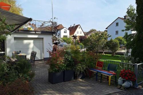 eine Terrasse mit einem Tisch und einigen Pflanzen und ein Haus in der Unterkunft Cosy Holiday Home in Mohnesee in Möhnesee