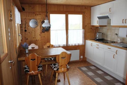 eine Küche mit einem Tisch und Stühlen im Zimmer in der Unterkunft Sennastübli in Bühler