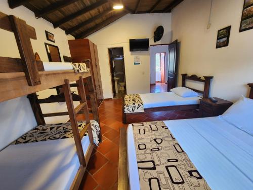 a room with three bunk beds in a room at Hotel Campestre Palmas del Zamorano in San Gil