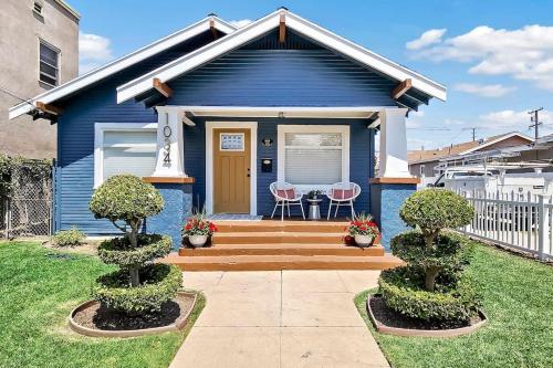 a blue house with two chairs in front of it at Historic Hm Mins to Beach, Convention Ctr Parking LB E in Long Beach