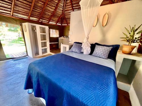 a bedroom with a blue bed in a room at Vista Do Deus Resort in Ligogo
