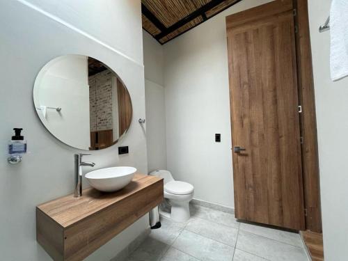 a bathroom with a sink and a mirror and a toilet at Pepe's House Usaquén I Cozy Hotel in Bogotá