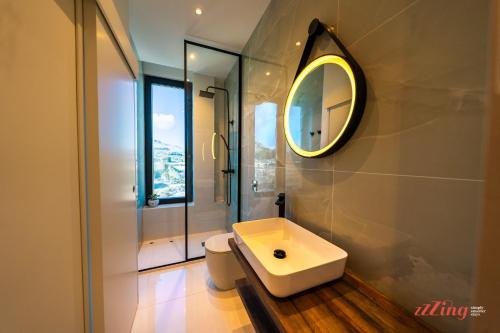 uma casa de banho com um lavatório e um espelho em A Stylishly Dreamy Gozo Apartment em Marsalforn