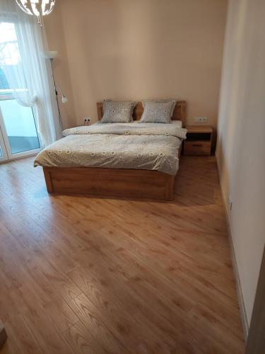 a bedroom with a bed and a wooden floor at Apartament in Legionowo