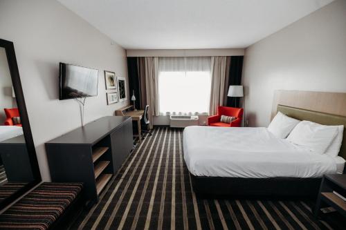 a hotel room with a bed and a television at Country Inn & Suites by Radisson, Lancaster Amish Country , PA in Lancaster