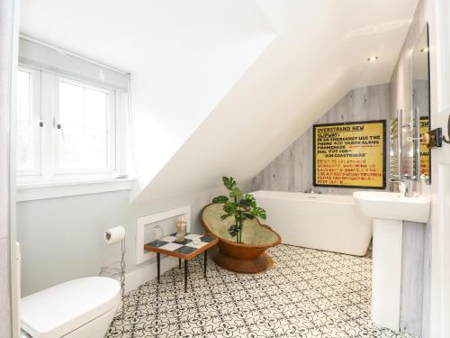 een badkamer met een bad, een wastafel en een toilet bij Beckhythe Cottage in Cromer