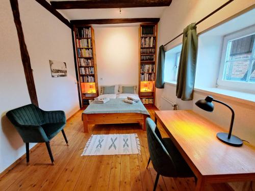 a room with a bed and a desk and a chair at Ferienwohnung im Heidjerhaus in Suderburg