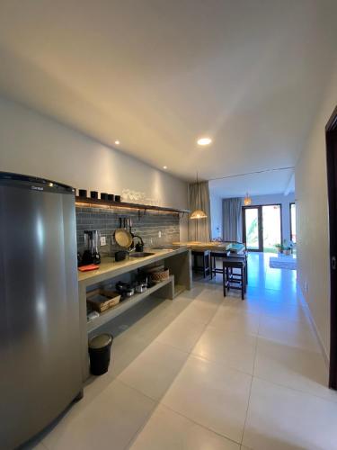 a large kitchen with a dining room and a table at Zenhousepipa in Pipa