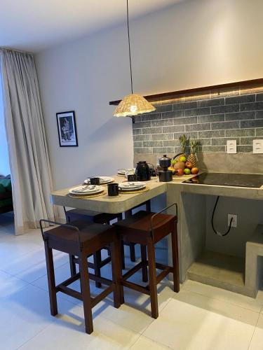 a kitchen with a table with two chairs and a sink at Zenhousepipa in Pipa