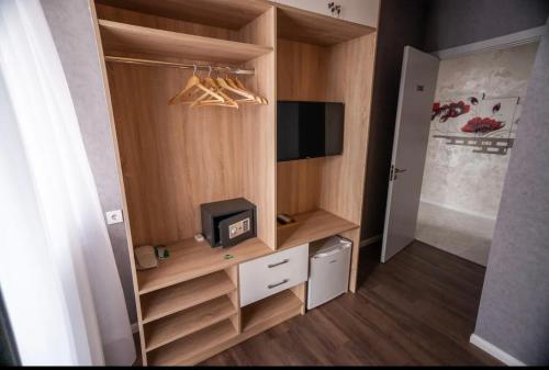 a room with a closet with a tv and a cabinet at Hotel Babi in Tbilisi City