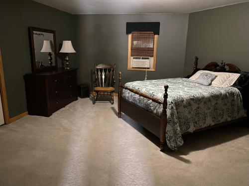 a bedroom with a bed and a chair and a mirror at Luxury 3-Bedroom home in Caribou