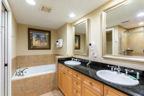 a bathroom with two sinks and a bath tub and a tubermott at 1 Portofino 1005 at Pensacola Beach in Pensacola Beach