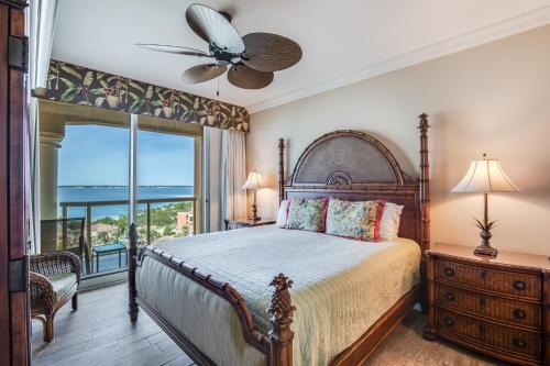 a bedroom with a bed with a fan and a window at 1 Portofino 1005 at Pensacola Beach in Pensacola Beach