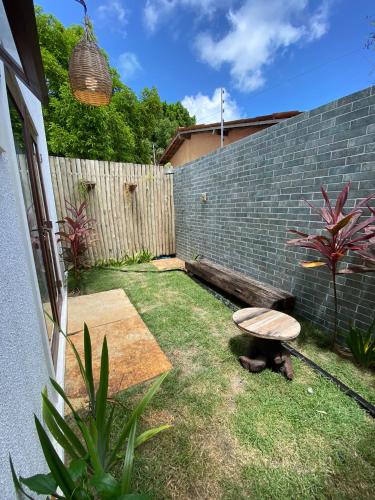 a small backyard with a bench and a fence at Zenhousepipa in Pipa