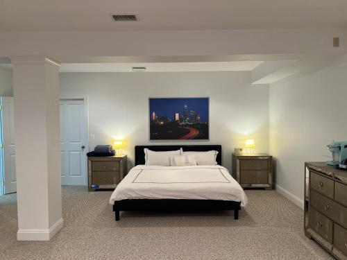 een slaapkamer met een bed, 2 dressoires en een schilderij bij Cozy 1B1B Suite 