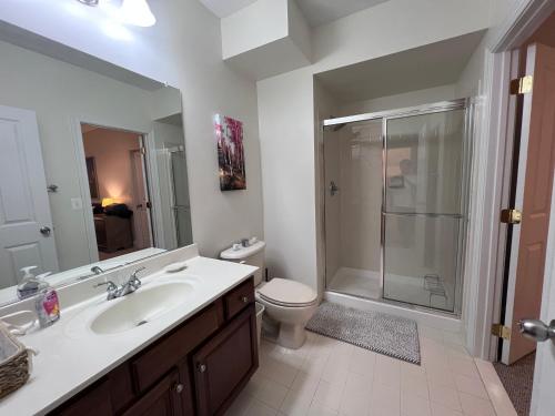 een badkamer met een wastafel, een toilet en een douche bij Cozy 1B1B Suite 